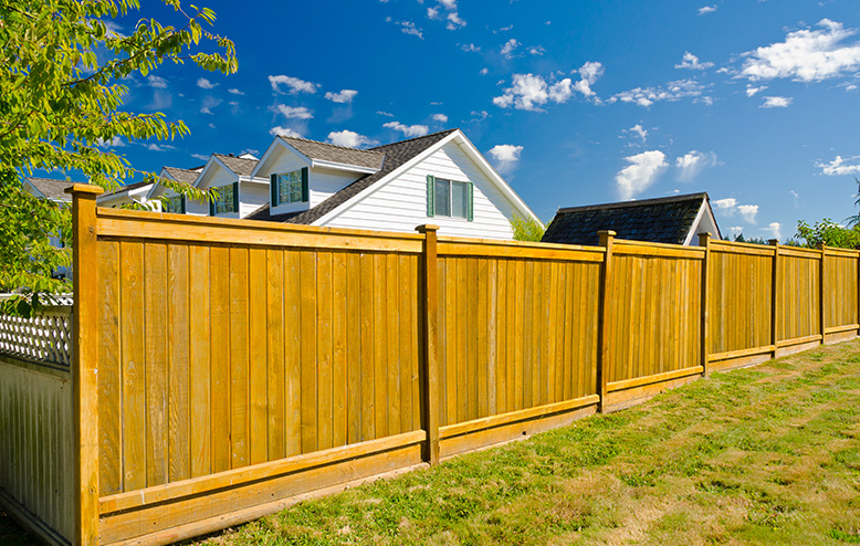 fence posts on helical piles in a grass yard installation